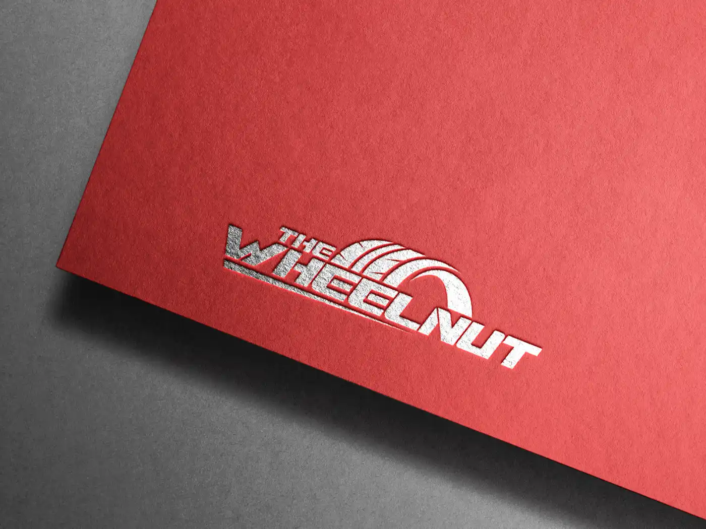 The Wheelnut logo silver foiled and embossed on red textured paper