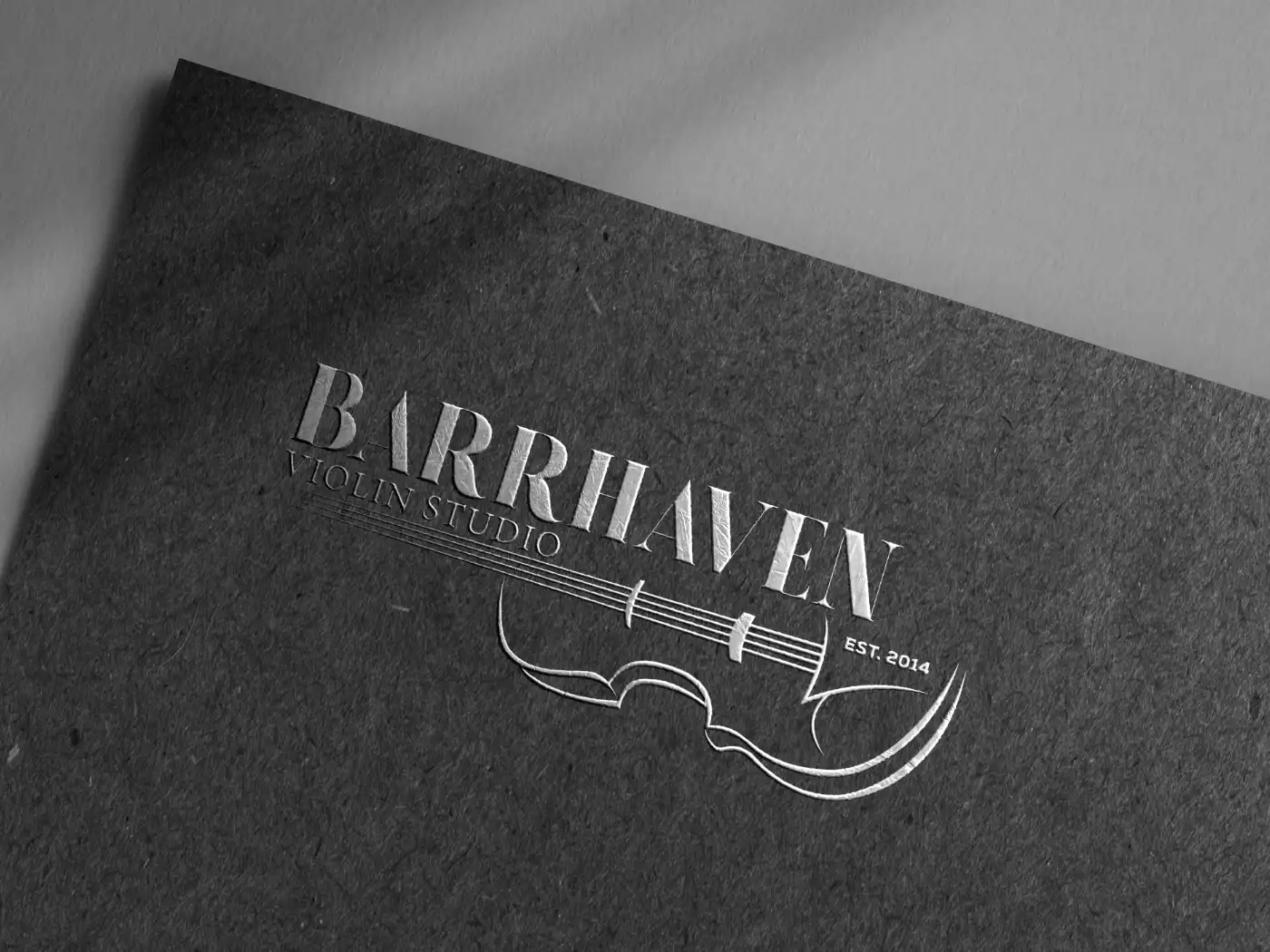 Barrhaven Violin School logo in silver on a black textured piece of paper